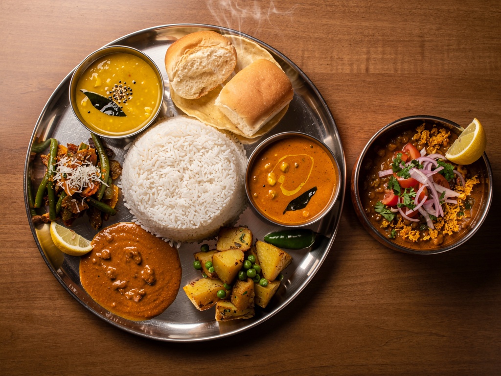 A Maharashtrian thali meal with rice, dal, curry and misal pav